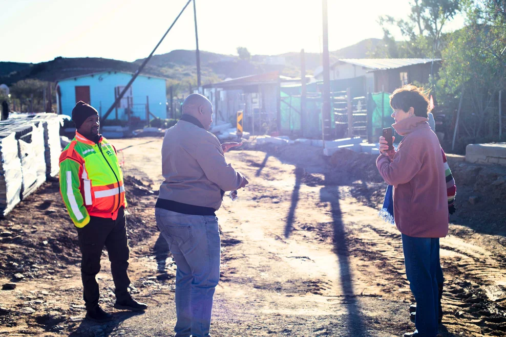 Mayor and team talking at building site