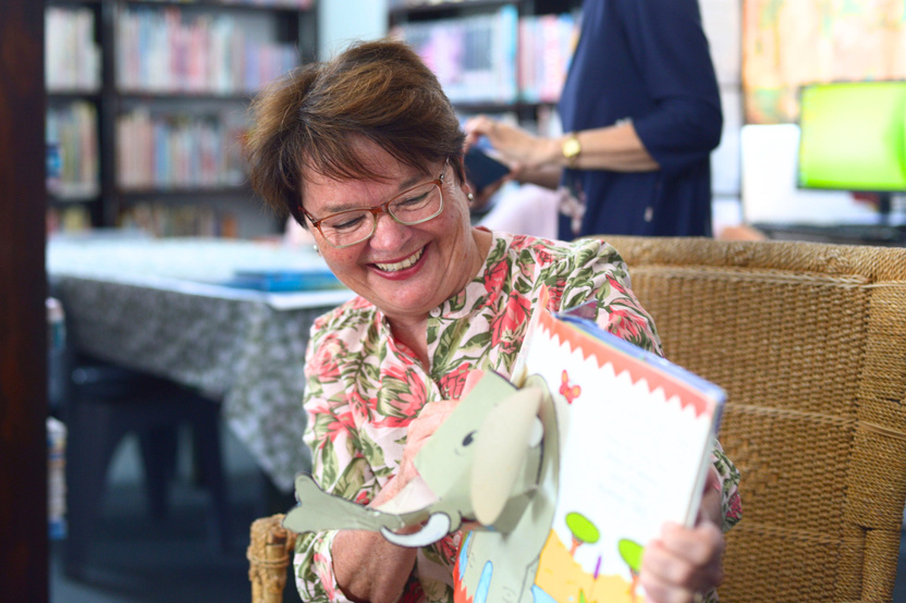 Mayor Jaquet smiling and showing kids animals in a childrens book