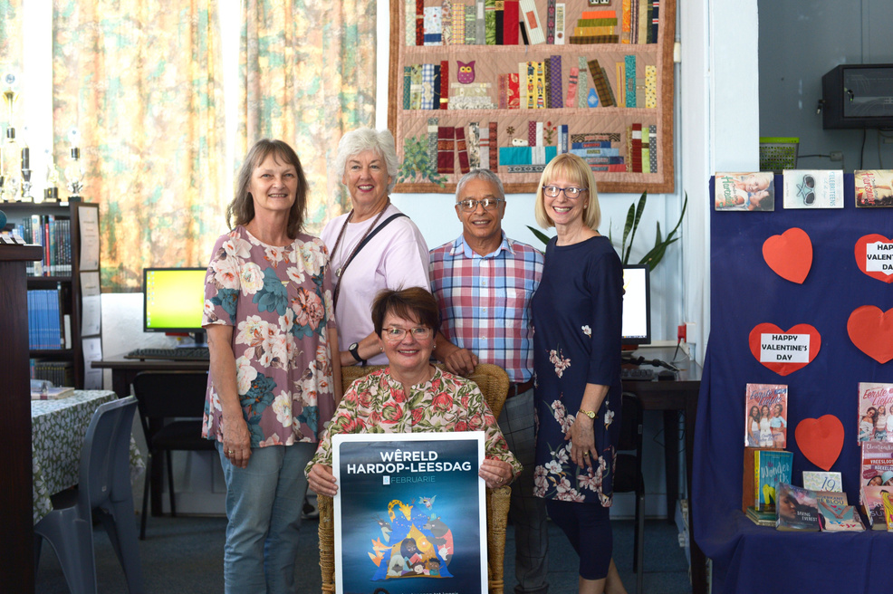 Mayor and library staff posing with a poster about World Read Aloud Day